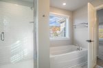 The Primary Bathroom Features a Large Soaking Tub and Separate Shower